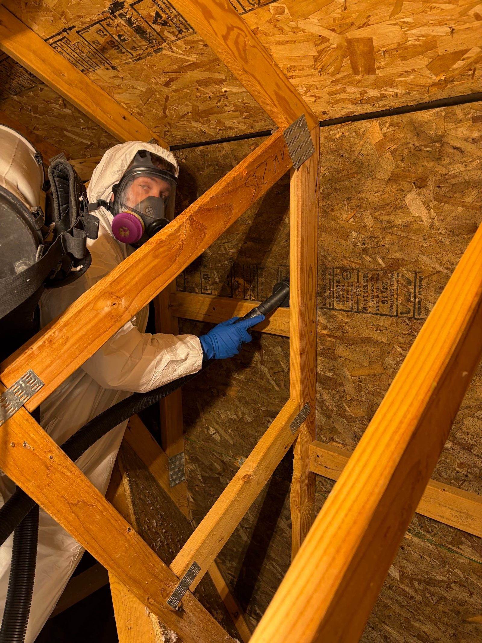 Restoration technician in a respirator inspecting a residential crawl space